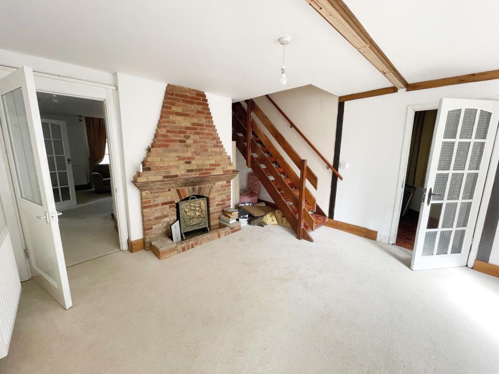 Lot: 62 - DETACHED FORMER GATEHOUSE FOR IMPROVEMENT - Reception room with fireplace and stair to first floor